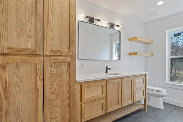 a bathroom with a sink a toilet and mirror