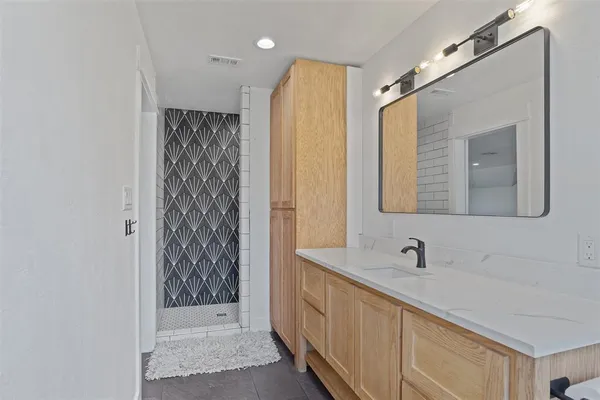 a bathroom with a double vanity sink mirror and shower