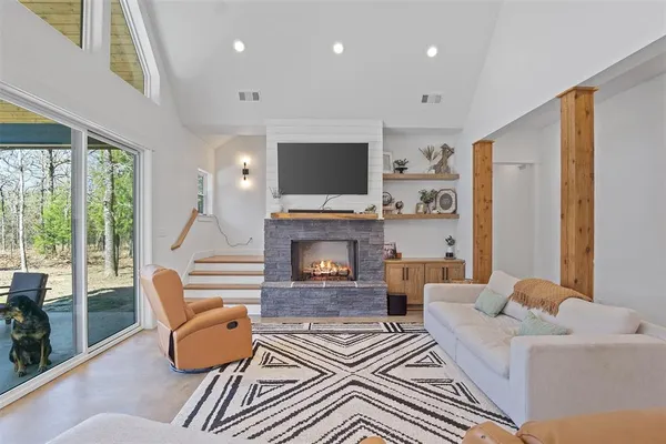 a living room with furniture a flat screen tv and a fireplace