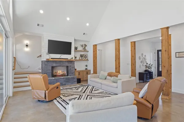 a living room with furniture a fireplace and a flat screen tv