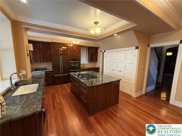 an empty room with a windows and chandelier fan