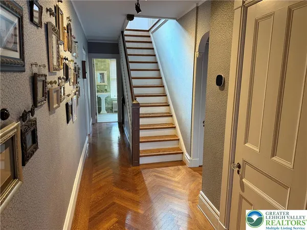 a view of a hallway with wooden floor and staircase