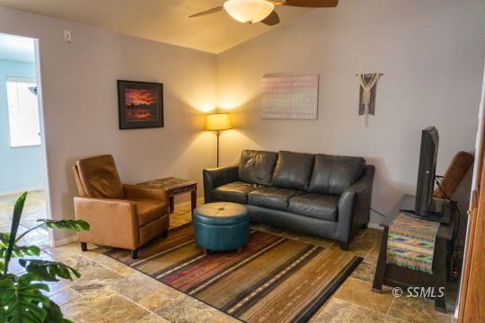 718 La Paloma Street Ridgecrest, CA 93555 - Photo 31 of 50 a living room with furniture a lamp and a rug