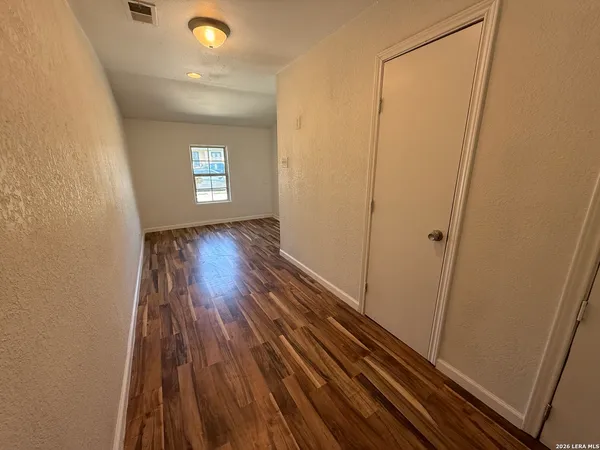 a view of a room with wooden floor and window