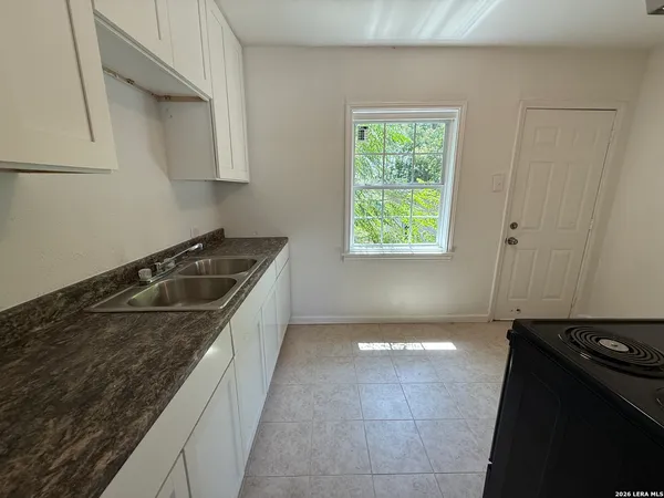 a kitchen with a sink stove and cabinets