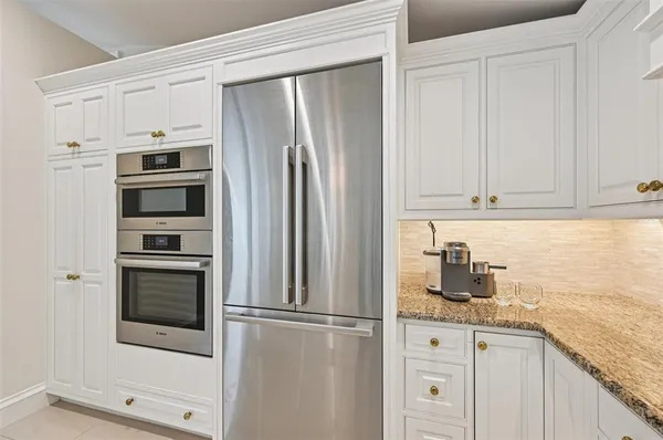 a kitchen with granite countertop white cabinets and white appliances