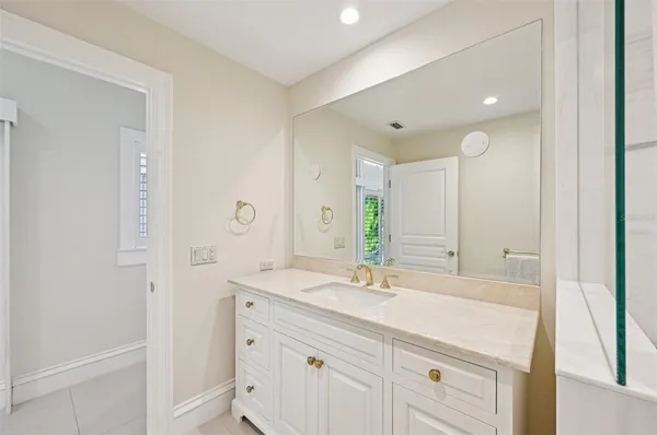 a bathroom with a sink vanity granite toilet and a mirror