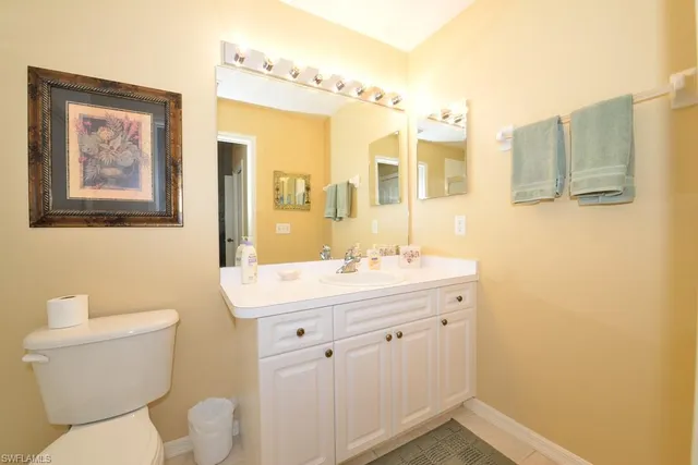 a bathroom with a granite countertop sink mirror vanity and toilet