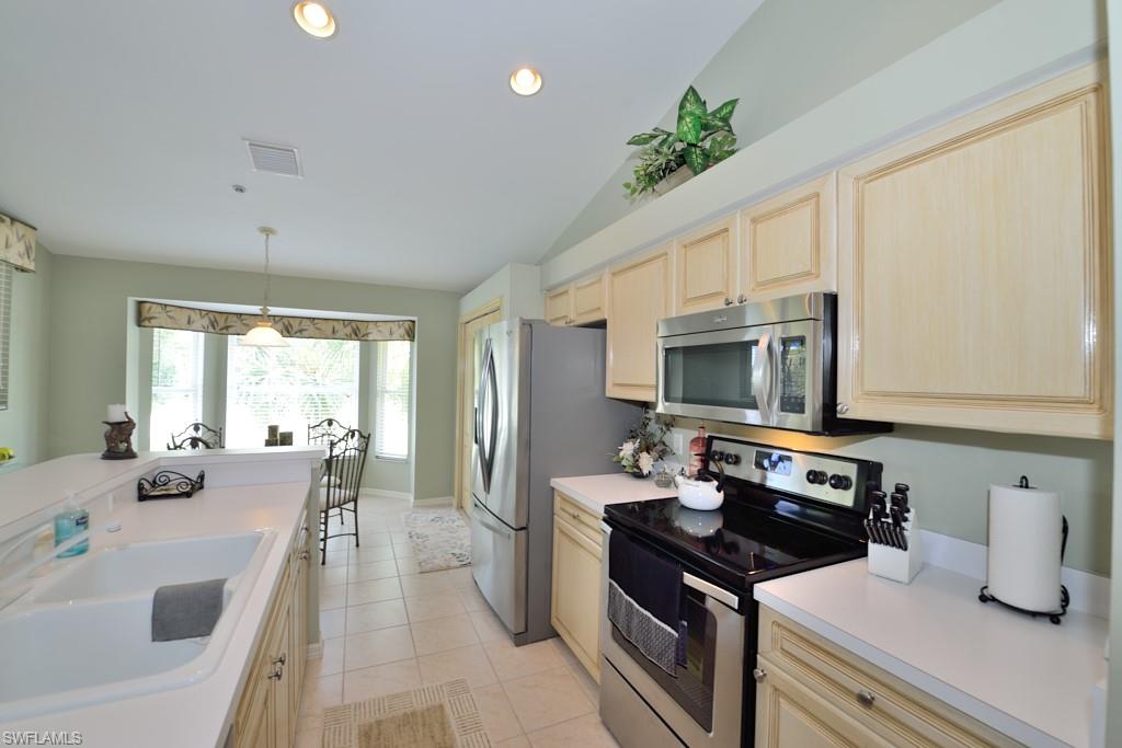 21370 Lancaster Run, Unit 1622 Estero, FL 33928 - Photo 7 of 28 a kitchen with stainless steel appliances granite countertop a sink stove and refrigerator
