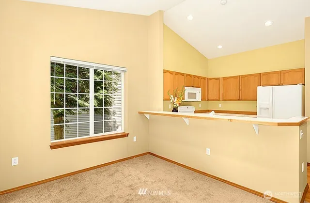 a view of a kitchen with wooden floor and a large window