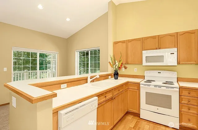 a view of a kitchen with cabinets and wooden floor