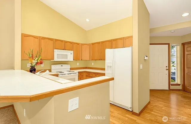 a kitchen with a refrigerator a stove a sink dishwasher and a refrigerator with wooden floor