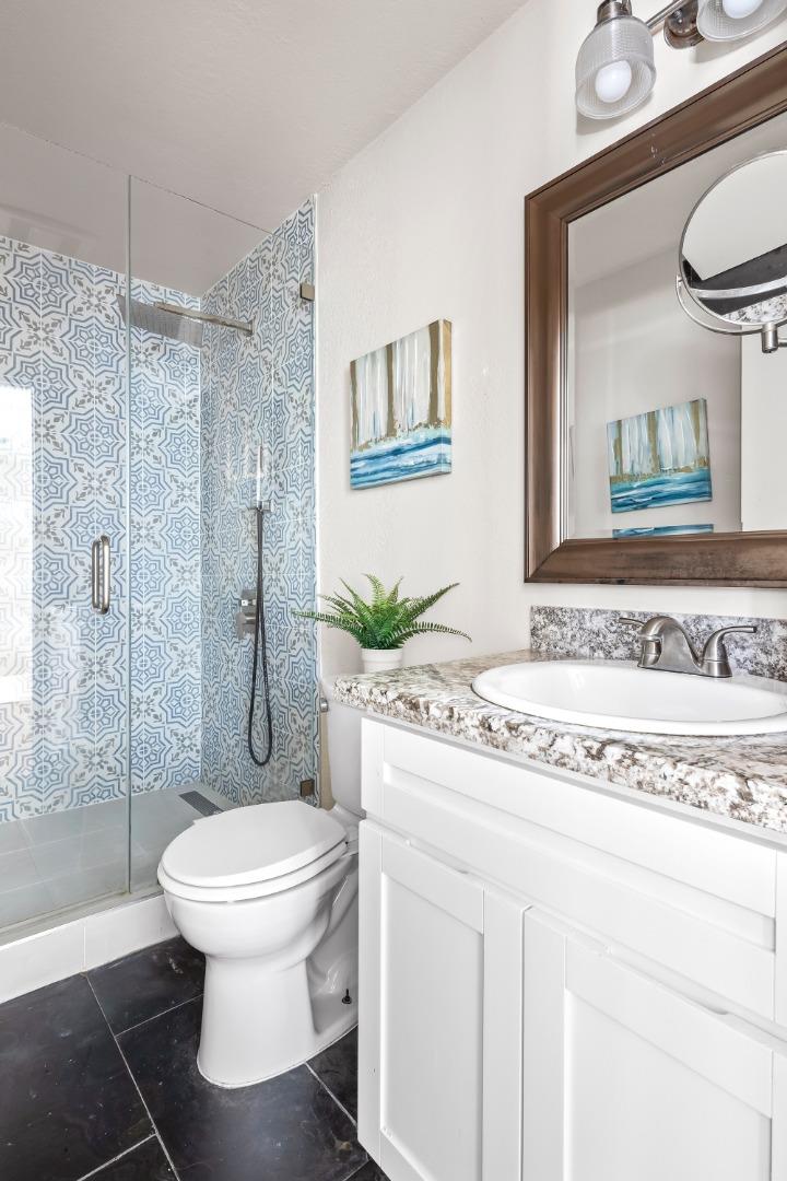 2001 Alameda De Las Pulgas, Unit 174 San Mateo, CA 94403 - Photo 13 of 16 a bathroom with a granite countertop sink toilet a mirror and shower
