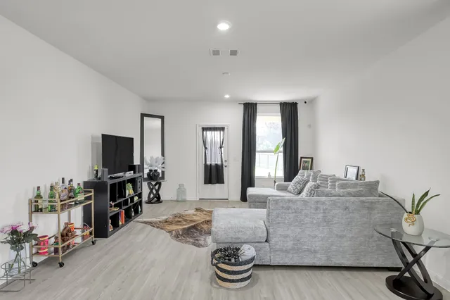 a living room with furniture and wooden floor