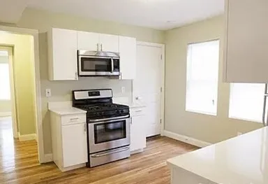 a kitchen with stainless steel appliances a stove a microwave and white cabinets