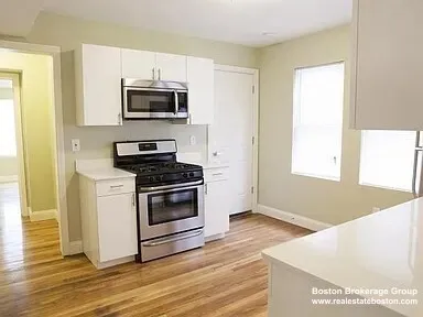 a kitchen with granite countertop a sink cabinets and stainless steel appliances