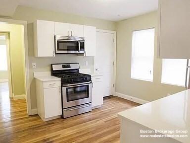 a kitchen with granite countertop a sink cabinets and stainless steel appliances
