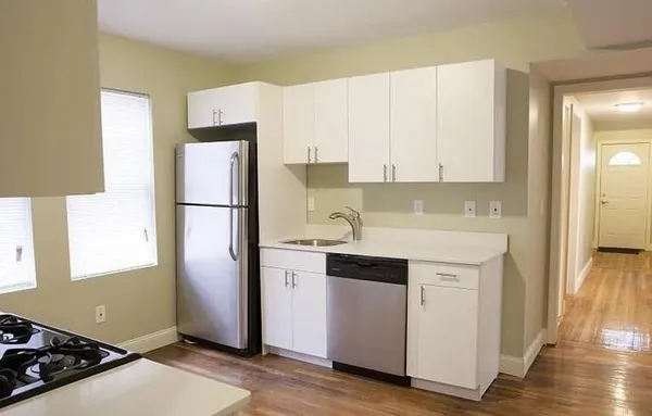 a kitchen with a refrigerator sink and cabinets