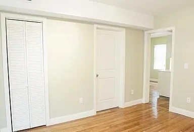 an empty room with wooden floor and closet
