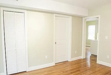 4043 Washington Street, Unit 2 Boston, MA 02131 - Photo 4 of 8 an empty room with wooden floor and closet
