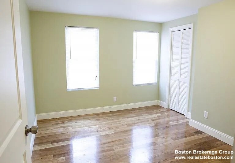 4043 Washington Street, Unit 2 Boston, MA 02131 - Photo 6 of 8 a view of an empty room with wooden floor and a window