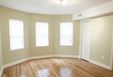 4043 Washington Street, Unit 2 Boston, MA 02131 - Photo 7 of 8 a view of an empty room with wooden floor and a window