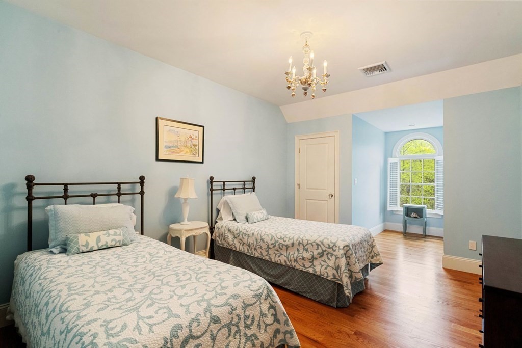 81 Pine Street Dover, MA 02030 - Photo 26 of 40 a bedroom with two beds and a chandelier