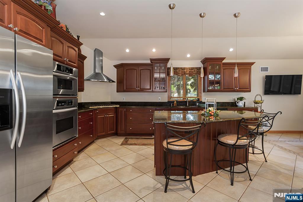 16 Barbara Way Wayne, NJ 07470 - Photo 11 of 35 a kitchen with stainless steel appliances granite countertop a sink a stove a refrigerator and chairs