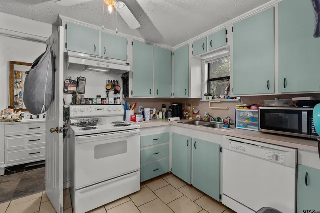 a kitchen with white cabinets and appliances