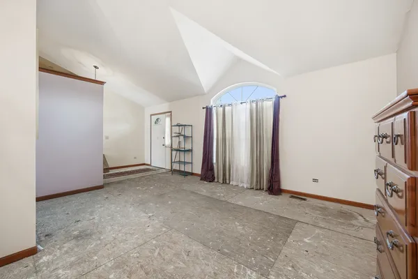 an empty room with closet and windows