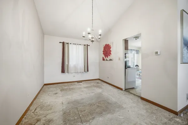 an empty room with windows and chandelier