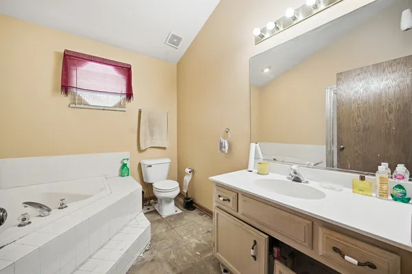 a bathroom with a tub sink and mirror on the wall
