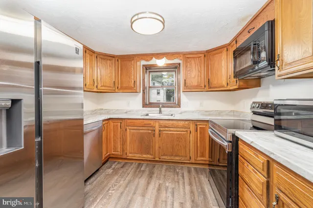 a kitchen with stainless steel appliances granite countertop a sink a stove and cabinets
