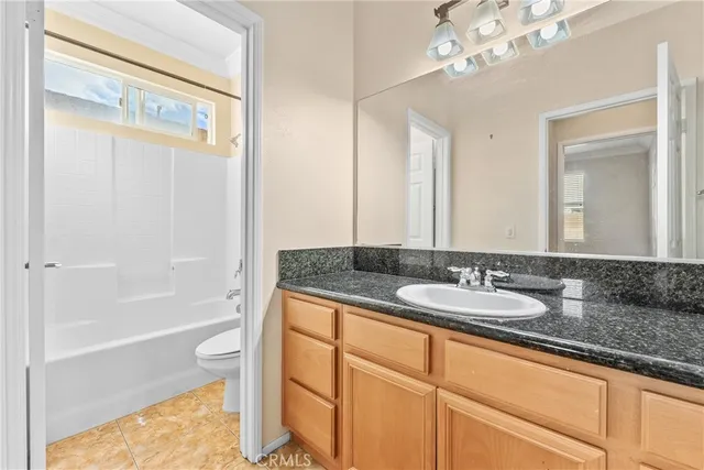 a spacious bedroom with a bed a couch and a chandelier