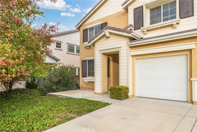 a view of a white house with a small yard and plants