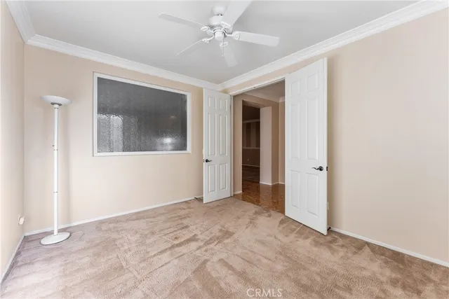 an empty room with a ceiling fan and a window