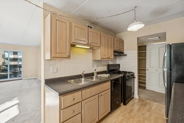 a kitchen with stainless steel appliances granite countertop a sink a stove a refrigerator and cabinets