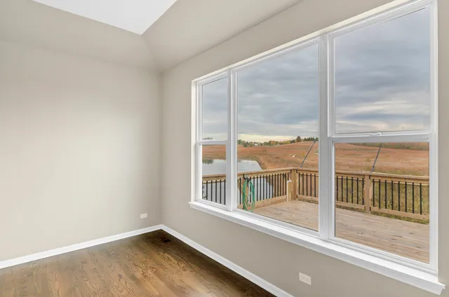a view of a big room with wooden floor kitchen view and windows