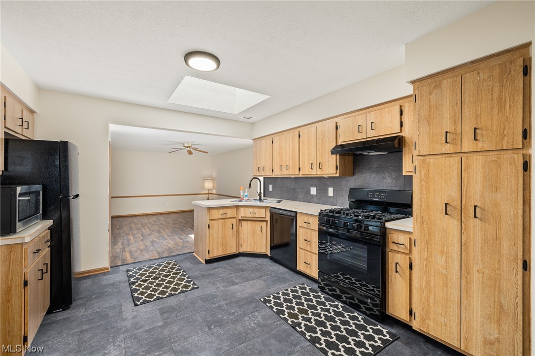 14495 Sheldon Road Cleveland, OH 44130 - Photo 8 of 27 Kitchen with a skylight, sink, ceiling fan, backsplash, and kitchen peninsula