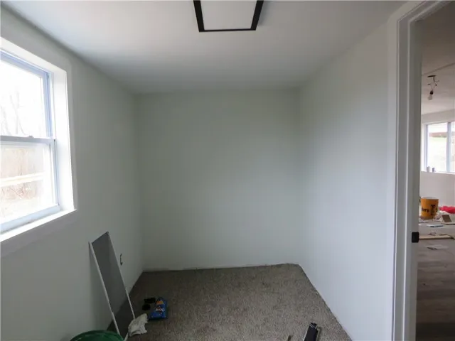 a view of a room that has a window and wooden floor