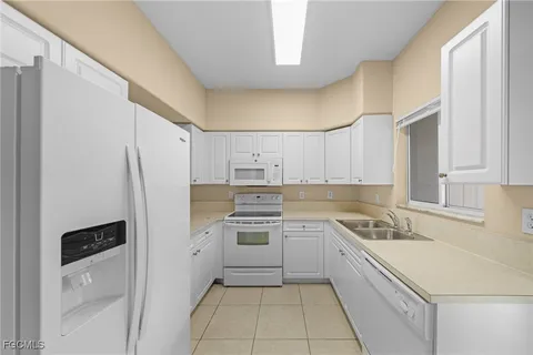 a kitchen with a sink a refrigerator and cabinets