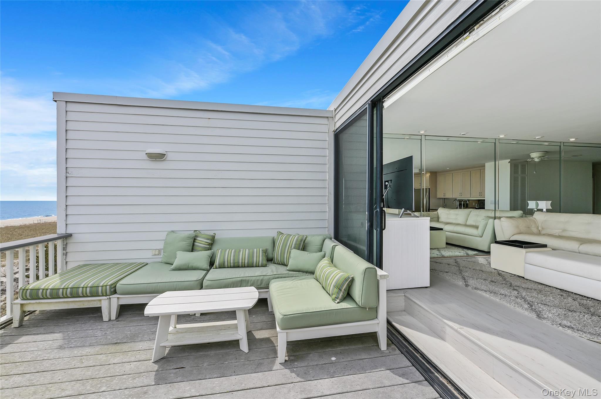 265 Dune Road, Unit 68 Westhampton Beach, NY 11978 - Photo 13 of 25 a view of a patio with couches and a potted plant on a table