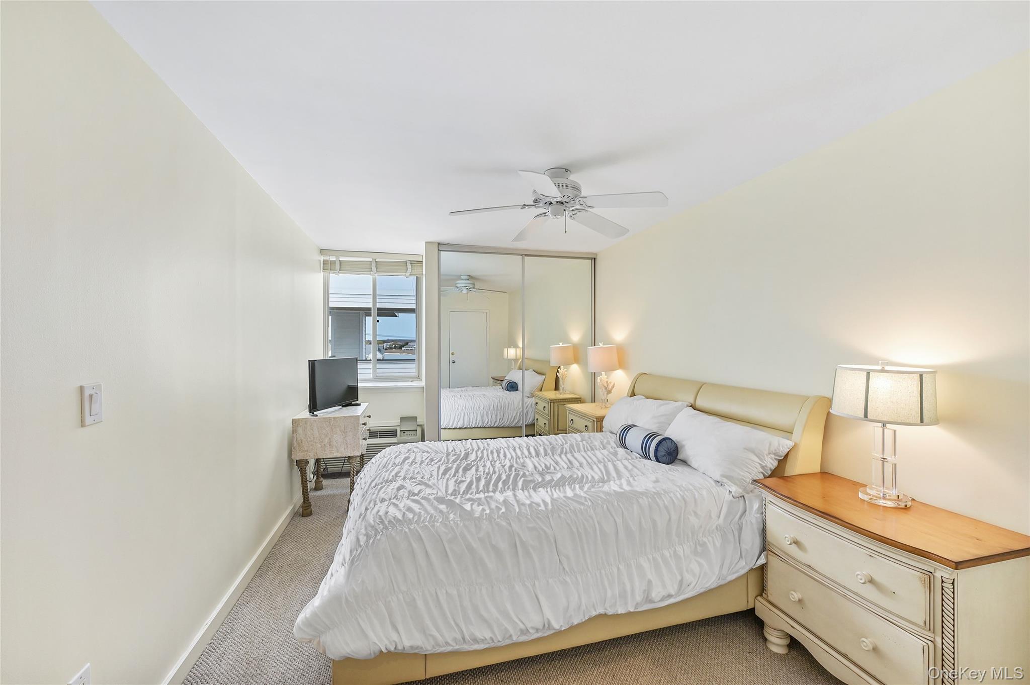 265 Dune Road, Unit 68 Westhampton Beach, NY 11978 - Photo 15 of 25 a bedroom with a bed and a night stand