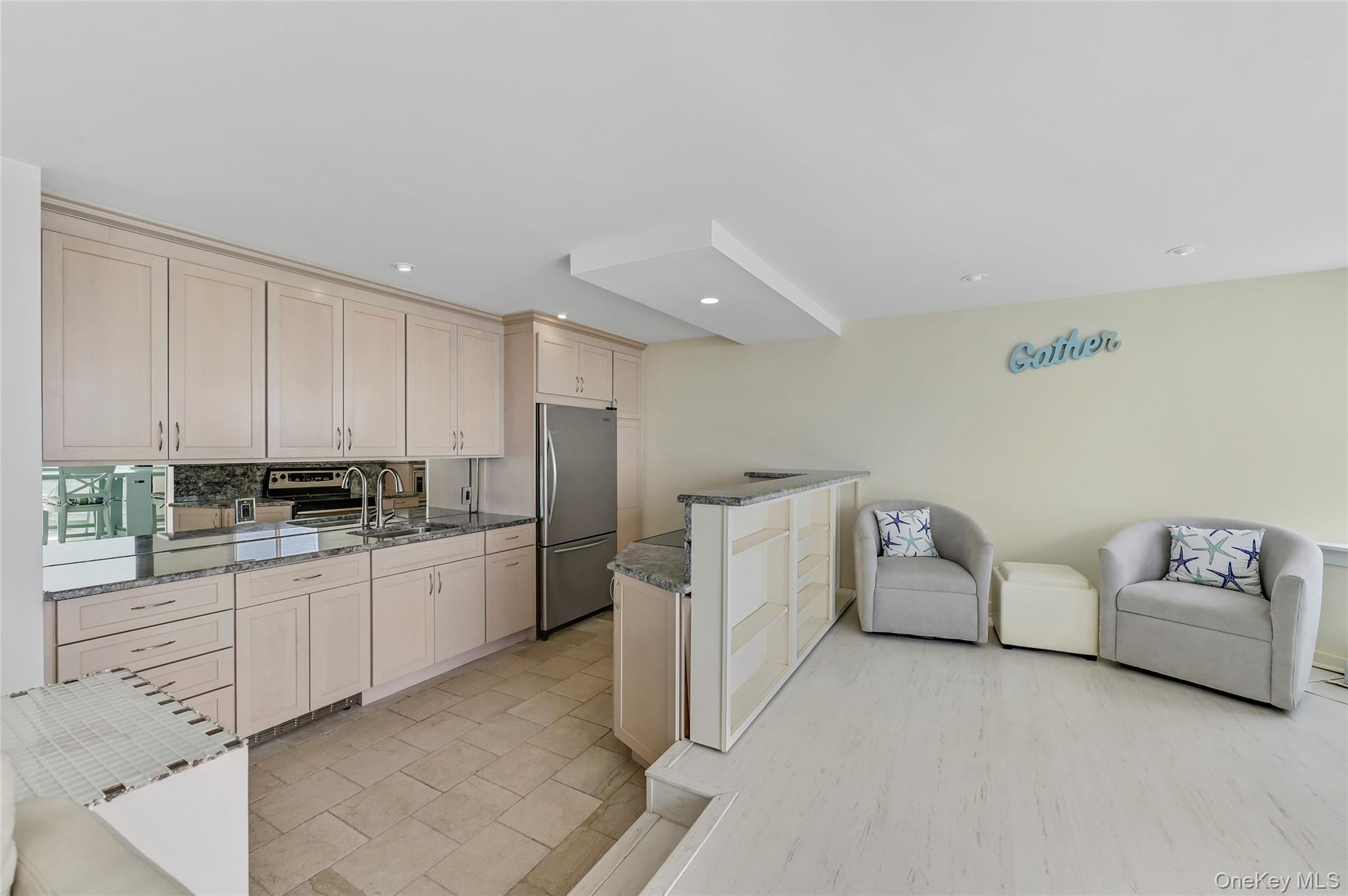 265 Dune Road, Unit 68 Westhampton Beach, NY 11978 - Photo 5 of 25 a large white room with kitchen island a furniture a refrigerator and a stove top oven