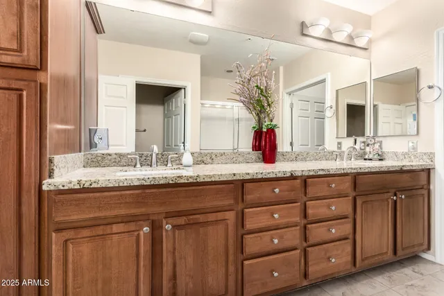a bathroom with a granite countertop sink and a large mirror