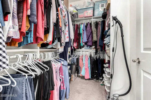 a view of walk in closet with clothes