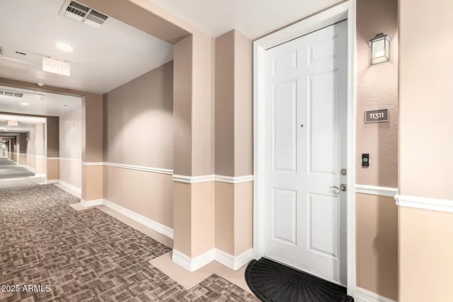 a view of a hallway with wooden floor and cabinet