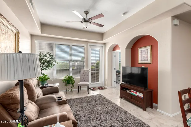 a living room with furniture a flat screen tv and a window