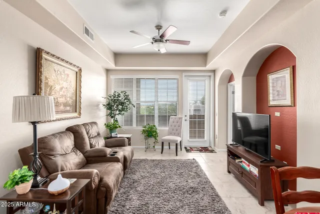 a living room with furniture a flat screen tv and a large window