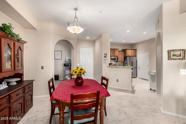 a kitchen with stainless steel appliances kitchen island granite countertop a sink a stove a dining table and chairs